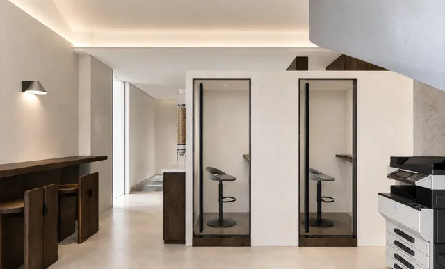 Render of enclosed phone booths next to an office printer